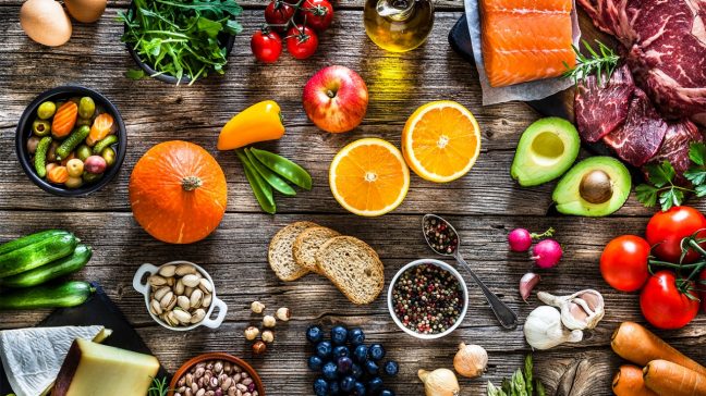 Healthy assortment of macronutrient-rich foods including vegetables, grains, tofu, legumes, avocado, and seeds – sources of carbs, proteins, and fats