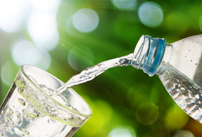 glass of water and bottle giving message to stay dehydrated